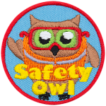 An owl wears an orange safety vest and safety glasses. The text Safety Owl is at the bottom.