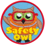 An owl wears an orange safety vest and safety glasses. The text Safety Owl is at the bottom.