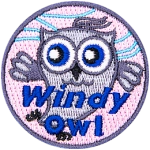 This grey owl dances in the wind. Whispy blue lines in the background indicate a breeze is blowing. The text Windy Owl is at the bottom.