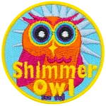 An orange and pink owl with a blue star behind it. The words Shimmer Owl are across its stomach.