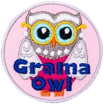A silver owl has a pearl necklace and matching earrings, as well as a pink dress and gold glasses. The words Grama Owl are across the bottom half.