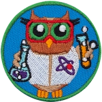 A brown owl dressed in a white lab coat and safety glasses holding two beakers of bubbling purple and orange liquids.