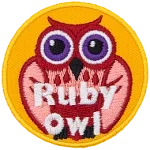 A red and pink owl with purple eyes. The words Ruby Owl are at the bottom.