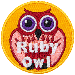 A red and pink owl with purple eyes. The words Ruby Owl are at the bottom.