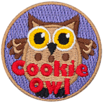 A fat brown owl with wide yellow eyes. The words Cookie Owl are stitched below.