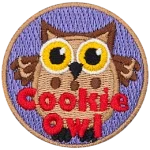 A fat brown owl with wide yellow eyes. The words Cookie Owl are stitched below.