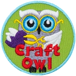 A white owl holding scissors and a paper heart. The words Craft Owl are at the bottom.