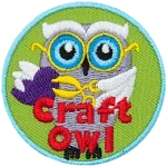 A white owl holding scissors and a paper heart. The words Craft Owl are at the bottom.