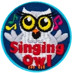 A chubby white owl with yellow eyes and eyelashes. The words Singing Owl are at the bottom.
