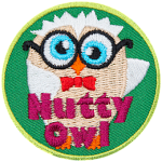 A cream and white owl with glasses and a red bowtie. The words Nutty owl are across the bottom.