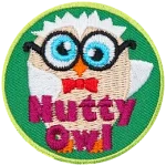 A cream and white owl with glasses and a red bowtie. The words Nutty owl are across the bottom.