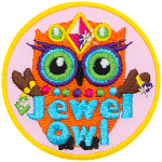 An orange owl wearing a crow, necklace and rings. The words Jewel Owl are across the bottom.