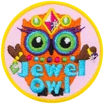 An orange owl wearing a crow, necklace and rings. The words Jewel Owl are across the bottom.