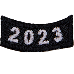 This black rocker curves upwards like a smile. The year number 2023 is embroidered in a bold font.