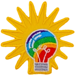 A rainbow-filled light bulb has a starburst behind it.