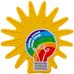 A rainbow-filled light bulb has a starburst behind it.