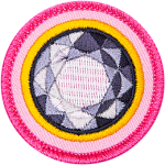 The top of a diamond is surrounded by a yellow ring on a pink background.