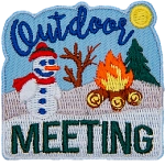 A snowman sits on a snow-covered hillside next to a roaring campfire. The text Outdoor Meeting frame the top and bottom of the patch.