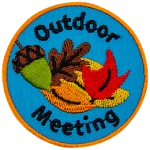 A pile of several leaves and an acorn are in the center of this patch. The words Outdoor Meeting are stitched around it.