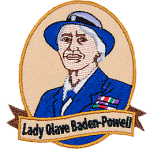 This patch displays a portrait of Lady Olave Baden-Powell wearing a blue and white hat and a blue blazer.