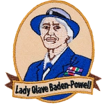 This patch displays a portrait of Lady Olave Baden-Powell wearing a blue and white hat and a blue blazer.
