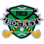 Two hockey sticks are crossed over each other with a ball on the shield-shaped field behind them. The words Field Hockey are stitched across the middle.