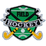 Two hockey sticks are crossed over each other with a ball on the shield-shaped field behind them. The words Field Hockey are stitched across the middle.