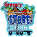 A shopping cart is loaded with food: a pepper, loaf of bread, apple, and carrots. The word Grocery sits above the cart, Store is written on the cart, and Tour rests under the cart but above the wheels.