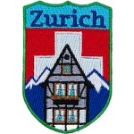The name Zurich is above the swiss alps and the swiss flag. A chalet sits in the foreground. 