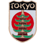 The name Tokyo is above a Pagoda in front of the flag of Japan.