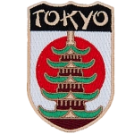 The name Tokyo is above a Pagoda in front of the flag of Japan.
