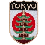 The name Tokyo is above a Pagoda in front of the flag of Japan.