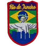 The words Rio de Janeiro are above Christ the Redeemer, which overlooks a blue silhouette of the city. The flag of Brazil is in the background.