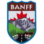 The name Banff is above a mountain landscape and road. The Canadian flag replaces the sky.