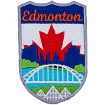 This emblem has the name Edmonton at the top on a blue background. In the section below, the name is Edmonton's famous landmarks. From bottom to top are the three pyramids of the Muttart Conservatory, the Waterdale Bridge, the North Saskatchewan River, and downtown Edmonton (including the Legislature Building). The background is a red maple leaf on a white backing.