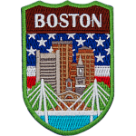 The skyline of Boston is in front of the flag of America. The name Boston is at the top.