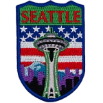 The Seattle space needle is in front of the American flag.