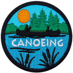 The silhouette of a person canoeing on a peaceful lake surrounded by forest scenery is displayed on this round patch.