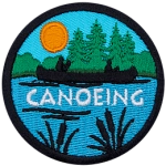 The silhouette of a person canoeing on a peaceful lake surrounded by forest scenery is displayed on this round patch.