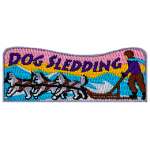 The words Dog Sledding are above a dog sled pulled by three dogs.