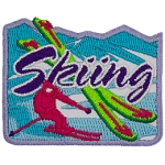 A pink skier is next to two crossed green skis. The word Skiing is across the middle.