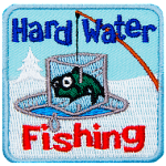 A fish frozen in an iceblock is pulled out of an ice fishing hole. The words Hard Water Fishing are above and below.