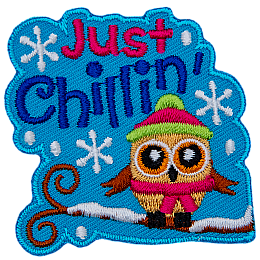 A little owl is bundled up in a toque and scarf as it sits on a snow-covered tree branch. The text Just Chillin' sits above it.