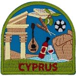 Kebabs, grapes, ancient structures, the ocean, wine, a soccer ball, and a lute are framed by a green border. Cyprus is embroidered below.
