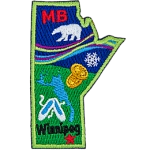 This crest is shaped like the province of Manitoba. Decorating it are the initials MB, a polar bear, the aurora Borealis, a snowflake, two loonie coins, a lake, a pair of slippers, and the capital Winnipeg.