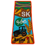 This patch is in the shape of the Canadian province of Saskatchewan with symbols such as the northern lights, grasslands, mountains, prairies, a tractor and a football helmet.