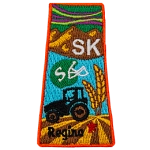This patch is in the shape of the Canadian province of Saskatchewan with symbols such as the northern lights, grasslands, mountains, prairies, a tractor and a football helmet.