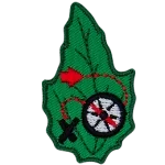 A compass with a red dotted line connected to it and an X on a green leaf.