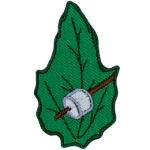 A marshmallow on a stick on a green leaf.
