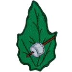 A marshmallow on a stick on a green leaf.